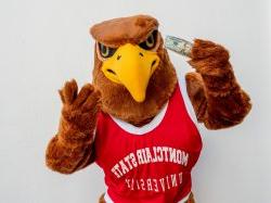 Rocky the Red Hawk holding up a twenty dollar bill.